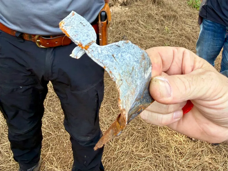 A person holds up a metal shard.