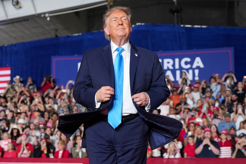 A white man in a blue suit on stage
