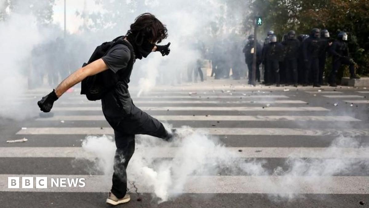 A masked student attempts to kick a tear gas canister amid clashes with French riot police during a demonstration by high school and university students, supported by teachers' union and school parents, in Paris as part of a nationwide day of protests and blockades, voicing anger over overcrowded classrooms, teacher shortages and dilapidated school buildings