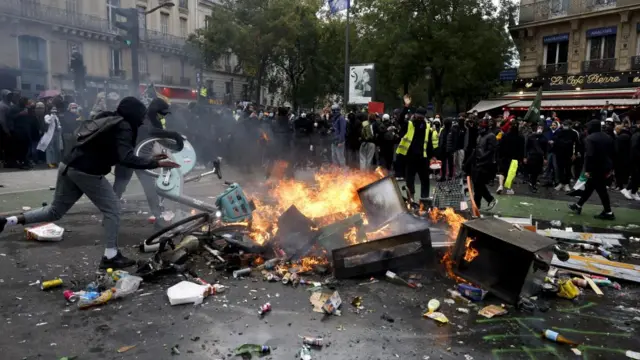 Two protesters put an electronic bike on a fire