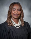 A woman in a judge’s robe smiles 