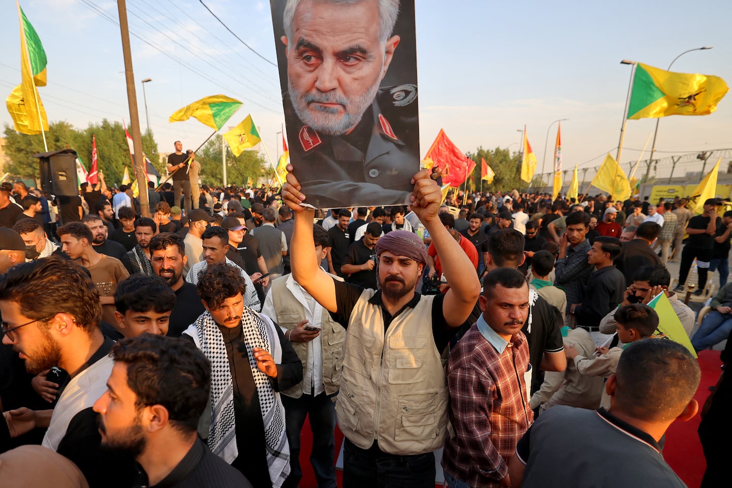 One of supporters of Iran-aligned armed factions holds up a portrait of Qassem Soleimani during a rally celebrating the withdrawal of forces of the US-led coalition against the Islamic State from Iraq, in Baghdad on September 30, 2026.