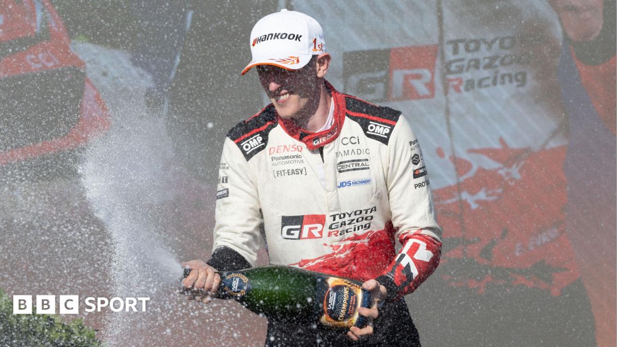 Elfyn Evans sprays champagne on the podium
