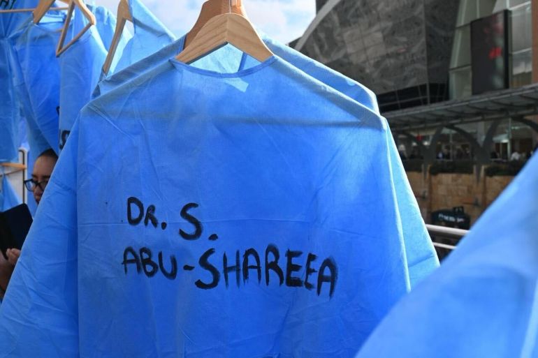 Empty scrubs containing names of detained Palestinian healthcare workers hang outside the WMA summit [Courtesy of IMA OUT! campaign]