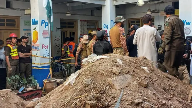 Rescuers next to a pile of rubble
