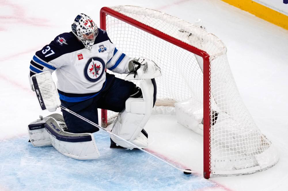Charles Krupa / Associated Press
Winnipeg Jets goaltender Connor Hellebuyck (37) slides the puck out of the net after a goal by Boston Bruins centre Fraser Minten on March 19, 2026, in Boston.