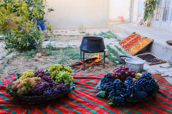 Freshly harvested grapes are displayed alongside traditional food preparation and drying trays in Ruyan, Semnan province, northern Iran, August 31, 2026. 