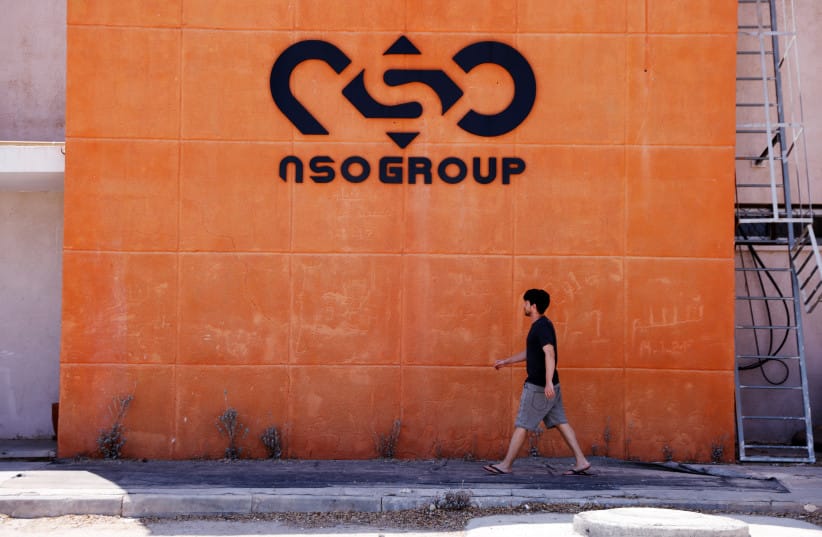 A man walks past the logo of Israeli cyber firm NSO Group at one of its branches in the Arava Desert, southern Israel July 22, 2021