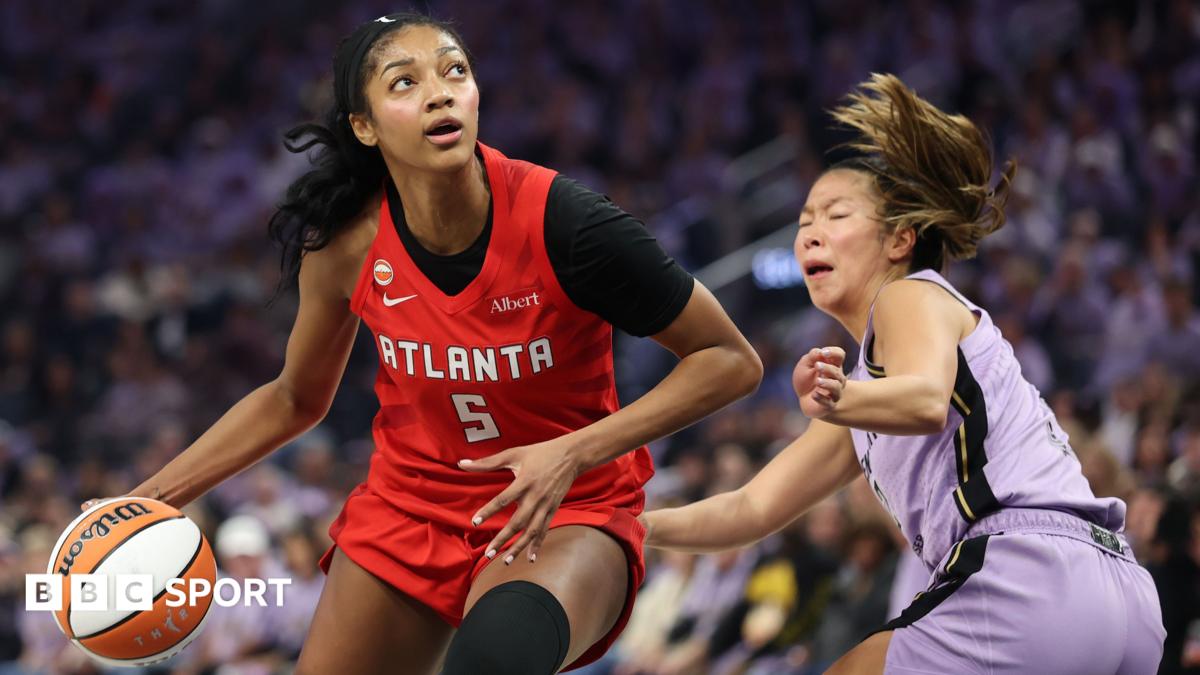 Angel Reese in a red Atlanta Dream kit, dribbles past Kaitlyn Chen in a mauve Golden State Valkyries kit