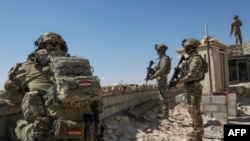 Kurdish Peshmerga fighters take position on the Qarachogh Mountain, about 60 kilometers south of Erbil, on the day US forces complete their withdrawal in Iraq on September 30, 2026.