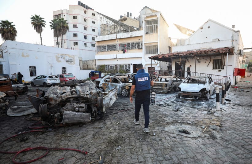 A member of the media walks at the area of Al-Ahli hospital in Gaza City, October 18, 2023