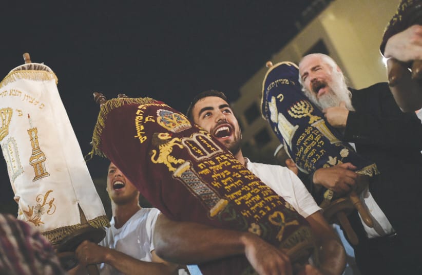 An illustrative image of Jews celebrating with Torah scrolls on Simchat Torah.