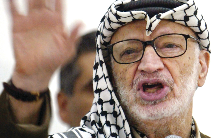 THEN-PALESTINIAN Authority head and PLO chairman Yasser Arafat gestures during a speech in Ramallah, 2004.