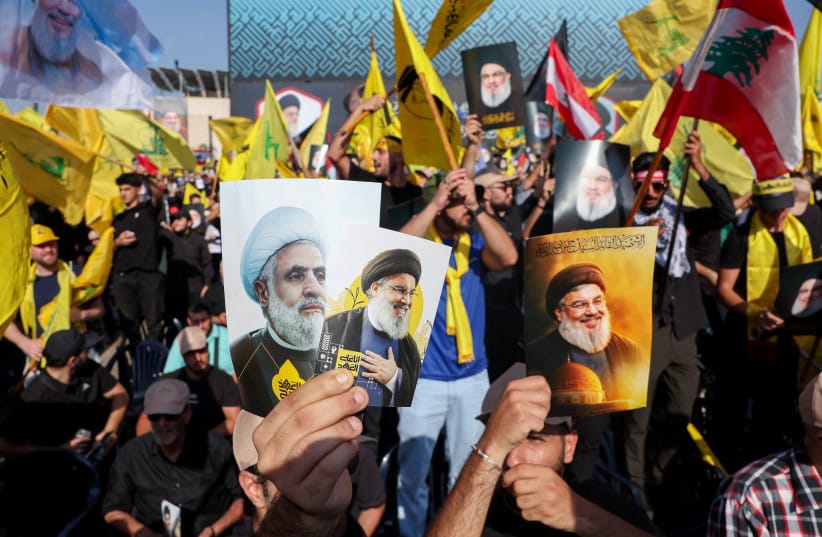 Hezbollah supporters hold images of late former Hezbollah leader Hassan Nasrallah and current leader Naim Qassem at a ceremony held by Hezbollah to commemorate the first anniversary of Hassan Nasrallah's killing by Israel, on the outskirts of Beirut, Lebanon, September 27, 2025.