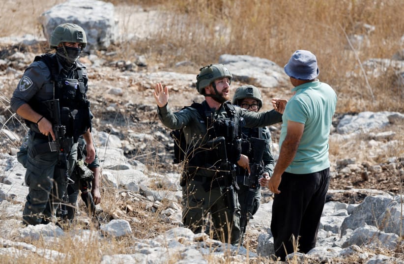 An Israeli soldier and a Palestinian man speak in Beit Lid, near Tulkarm, in the West Bank, November 7, 2025