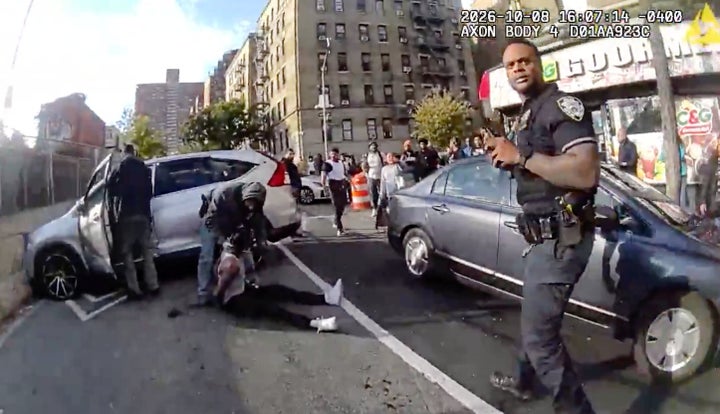 In this image, taken from police-worn body camera video released by the New York City Police Department (NYPD), law enforcement personnel tend to a Oscar Belgal, 28, a Dominican man who was shot by Federal immigration officers, on Oct. 8, 2026, in New York, as he drove his car with a 5-year-old boy inside. 
