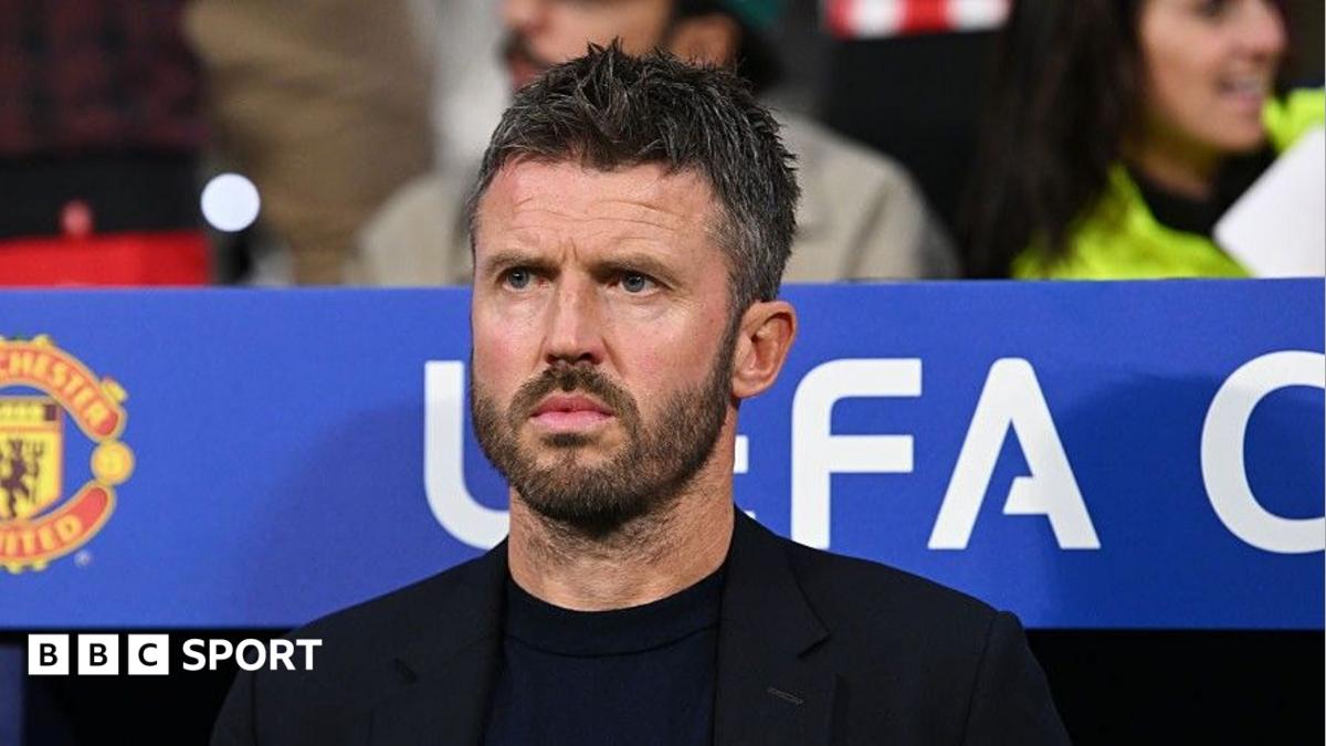 Michael Carrick, wearing a black T-shirt and black blazer, looks on from the dugout during a Champions League match