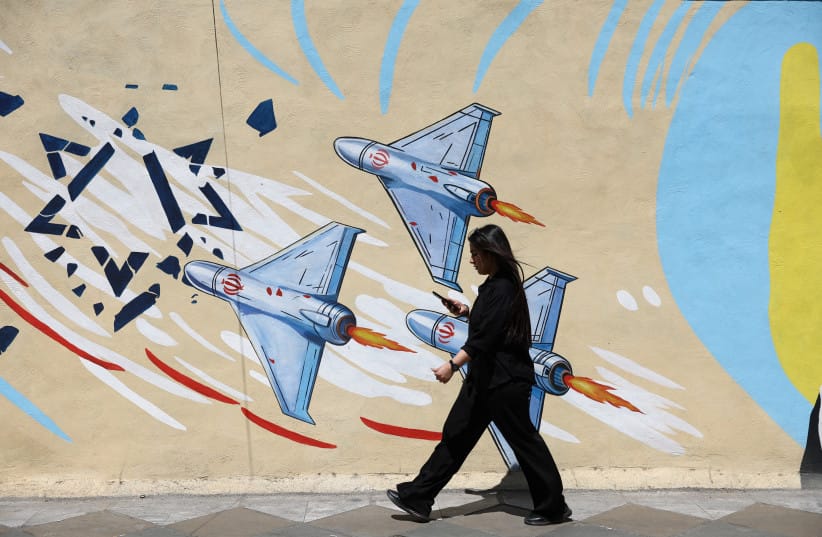 An Iranian woman walks next to an anti-Israeli mural on a street in Tehran, Iran, May 11, 2026.