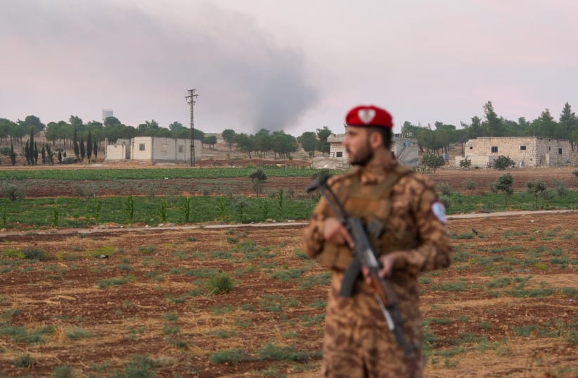 A military police officer stands on a road following an explosion at a weapons depot in the Al-Eis area, in the southern countryside of Aleppo, Syria, September 21, 2026.