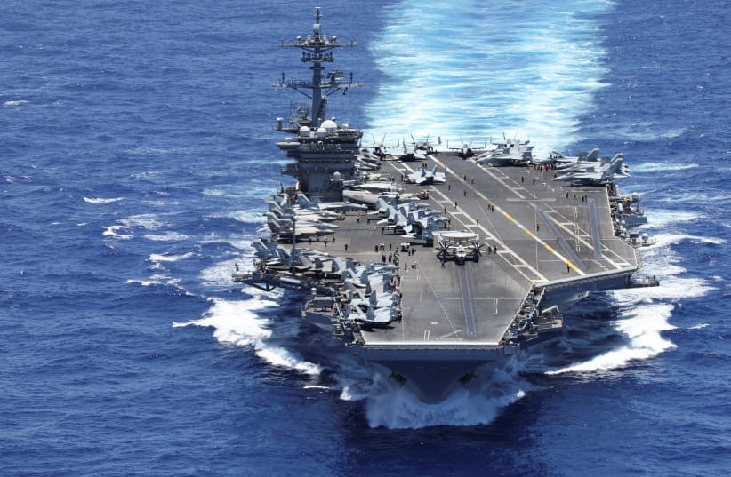 The USS Theodore Roosevelt from the bay doors of a V-22 Osprey after taking off during a Rim of the Pacific (RIMPAC) military exercise in waters south of the Hawaiian Islands, U.S., July 13, 2026. 