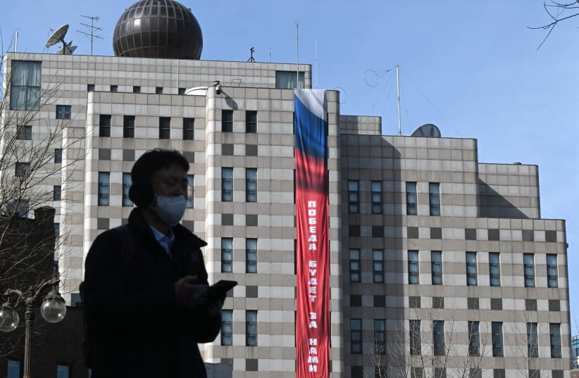 A man walks in front of the Russian embassy in Seoul on February 23, 2026, as a banner reading ''Victory will be ours'' is displayed on the exterior wall of the embassy. South Korea has protested to Russia after its embassy in Seoul unfurled a giant banner declaring ''Victory will be ours.''