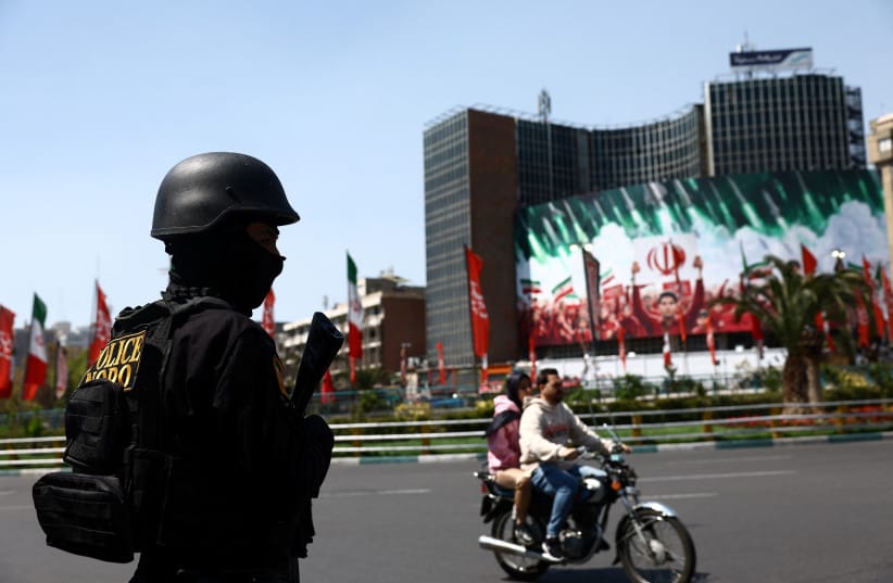 A member of a police force stands guard on a street, amid the U.S.-Israeli conflict with Iran, in Tehran Wednesday, 1st April 2026