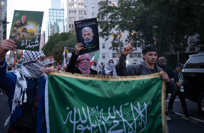 Pro-Palestinian protesters hold a Hamas flag and a photo of Yahya Sinwar, the mastermind of the Oct. 7, 2023, attack as they march toward Union Square.