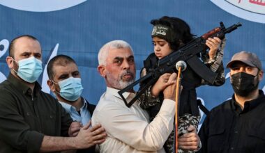 Hamas leader Yahya Sinwar holds the child of an Al-Qassam Brigades fighter, who was killed in the recent fighting with Israel, with a Kalashnikov rifle in his hand during a rally in Gaza City on May 24, 2021.