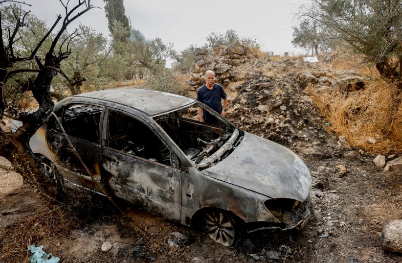 Illustrative: A Palestinian man inspects a burned vehicle following an alleged attack by extremist Jewish settlers in the West Bank village of Mikhmas, northeast of Jerusalem, October 14, 2026.