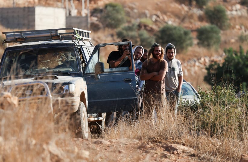 Israeli settlers gather during the olive harvest at Palestinian-owned olive groves in Deir Abu Mashal, near Ramallah, in the West Bank, October 19, 2026.