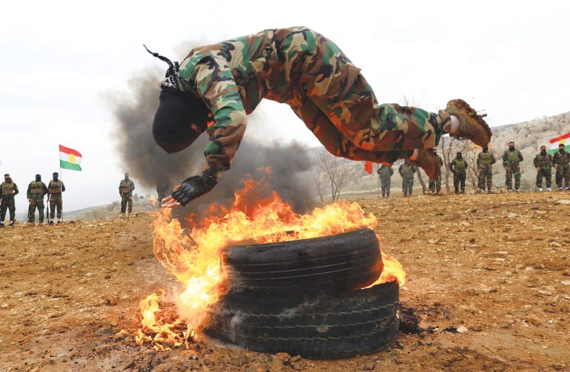 A FEMALE FIGHTER from from the Kurdistan Freedom Party (PAK) performs a training drill during an exercise at a base near Erbil, Iraq in Feb.