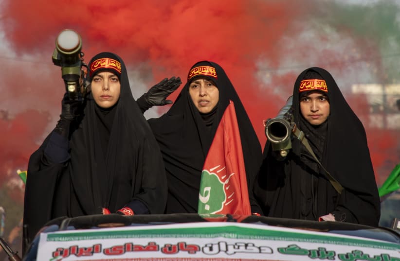 Women carrying weapons resembling shoulder-fired missiles ride in a truck during a pro-government National Army Day demonstration on April 17, 2026 in Tehran, Iran.