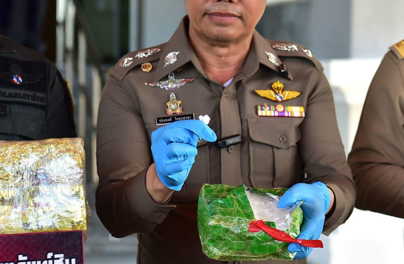 A Thai police official holds a sample of crystal methamphetamine following a seizure operation of the drug known as ''ice'' valued at 90 million baht (USD 2.6 million) in the southern Thai province of Narathiwat on October 1, 2026.