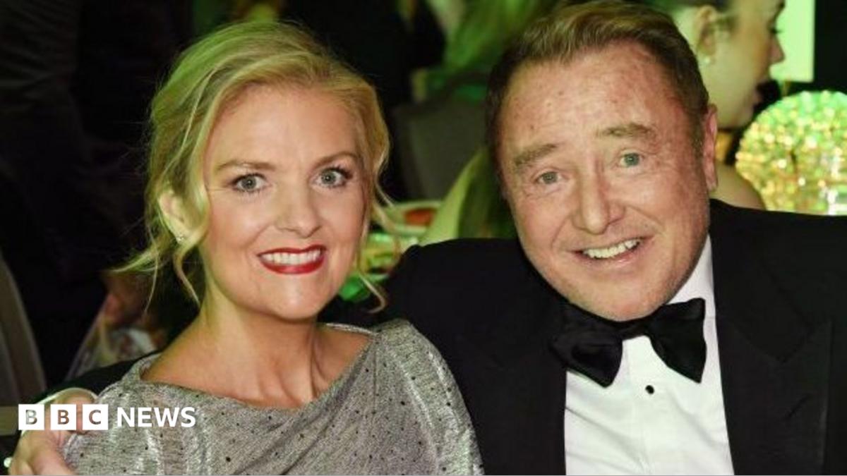 Niamh O'Brien and Michael Flatley attend The Irish Post Awards in 2024. Niamh has long, blonde hair, tied back and wears a silver dress. Michael has short, ginger hair and wears a black tuxedo.