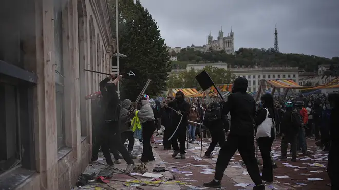Protesters attack a tourism office during a demonstration against rising living costs, joining students' grievances, in Lyon, France, Saturday, Oct. 17, 2026. (AP Photo/Laurent Cipriani)