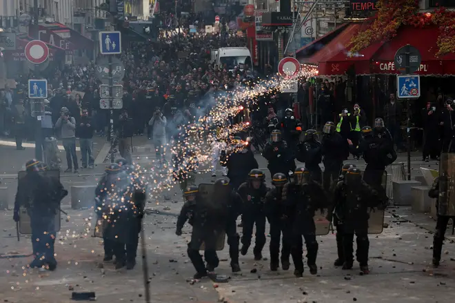 French riot police run amid clashes with protesters in Paris
