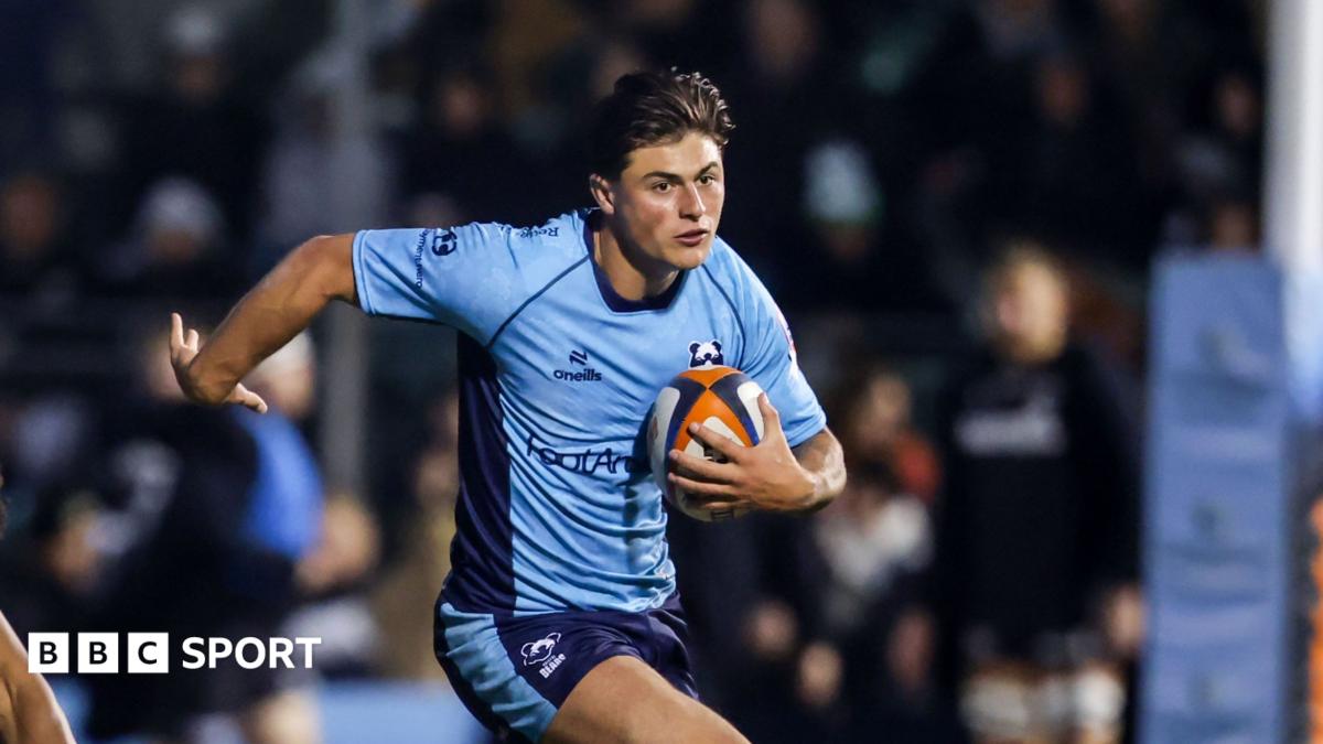 Louis Rees-Zammit runs with a rugby ball tucked to his body, wearing a light blue Bristol Bears away kit