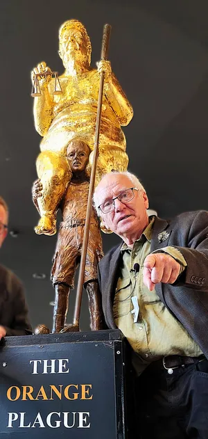 Danish sculptor Jens Galschiøt is photographed alongside his creation "The Orange Plague."