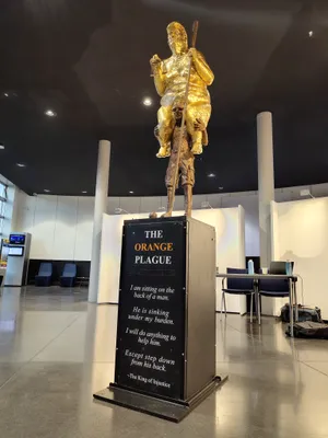 A gold statue of President Donald Trump sitting on the back of a frail man fully naked was unveiled in the European Parliament building in Strasbourg, France.