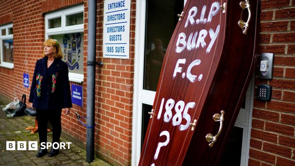 A brown coffin with the words "RIP Bury FC 1885" daubed on it in white paint, propped up outside the club's Gigg Lane ground