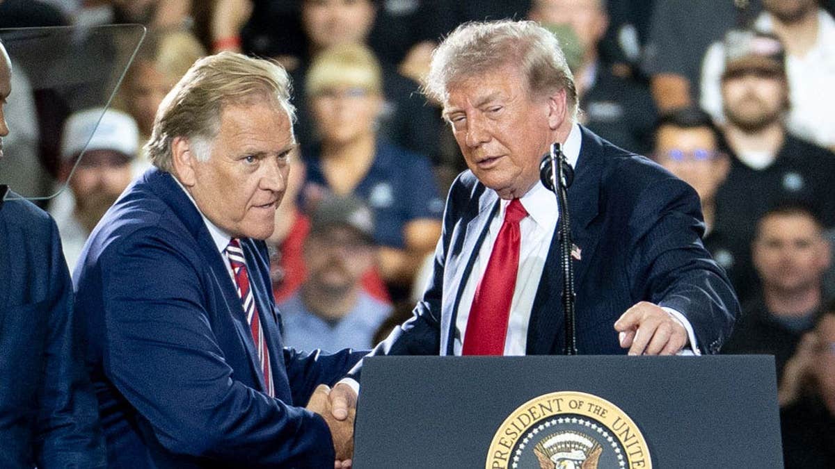 Former Rep. Mike Rogers shakes hands with President Donald Trump