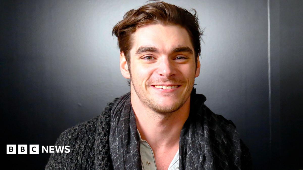 RJ Mitte smiling and wearing a blue top
