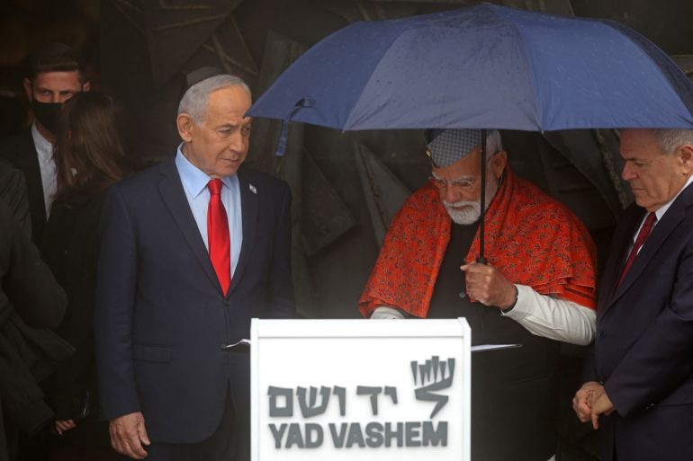 India’s Prime Minister Narendra Modi (C) signs the guestbook after paying respect at the Hall of Remembrance as his Israeli counterpart Benjamin Netanyahu (L) and Dani Dayan, chairman of the Yad Vashem Holocaust Memorial Museum, watch during Modi’s visit to the museum in Jerusalem on February 26, 2026