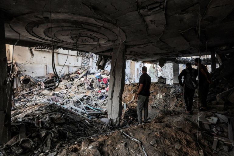 People inspect debris in a heavily-damaged building following an Israeli strike on a residential apartment in the Rimal neighbourhood of Gaza City