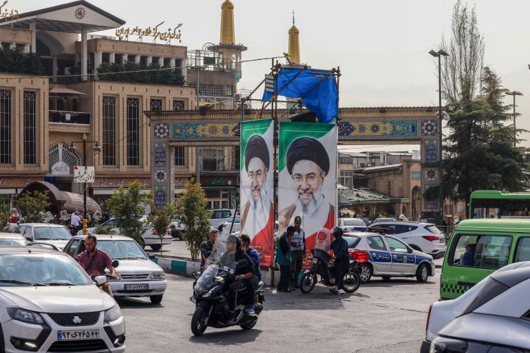 Traffic moves past portraits of Iran’s Supreme Leader Ayatollah Mojtaba Khamenei in Tehran on October 21, 2026