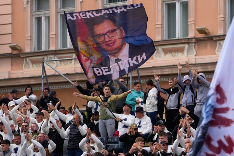 Supporters wave a flag showing Serbia’s populist leader Aleksandar Vucic during a rally for the governing Serbian Progressive Party in Novi Sad on October 16, 2026
