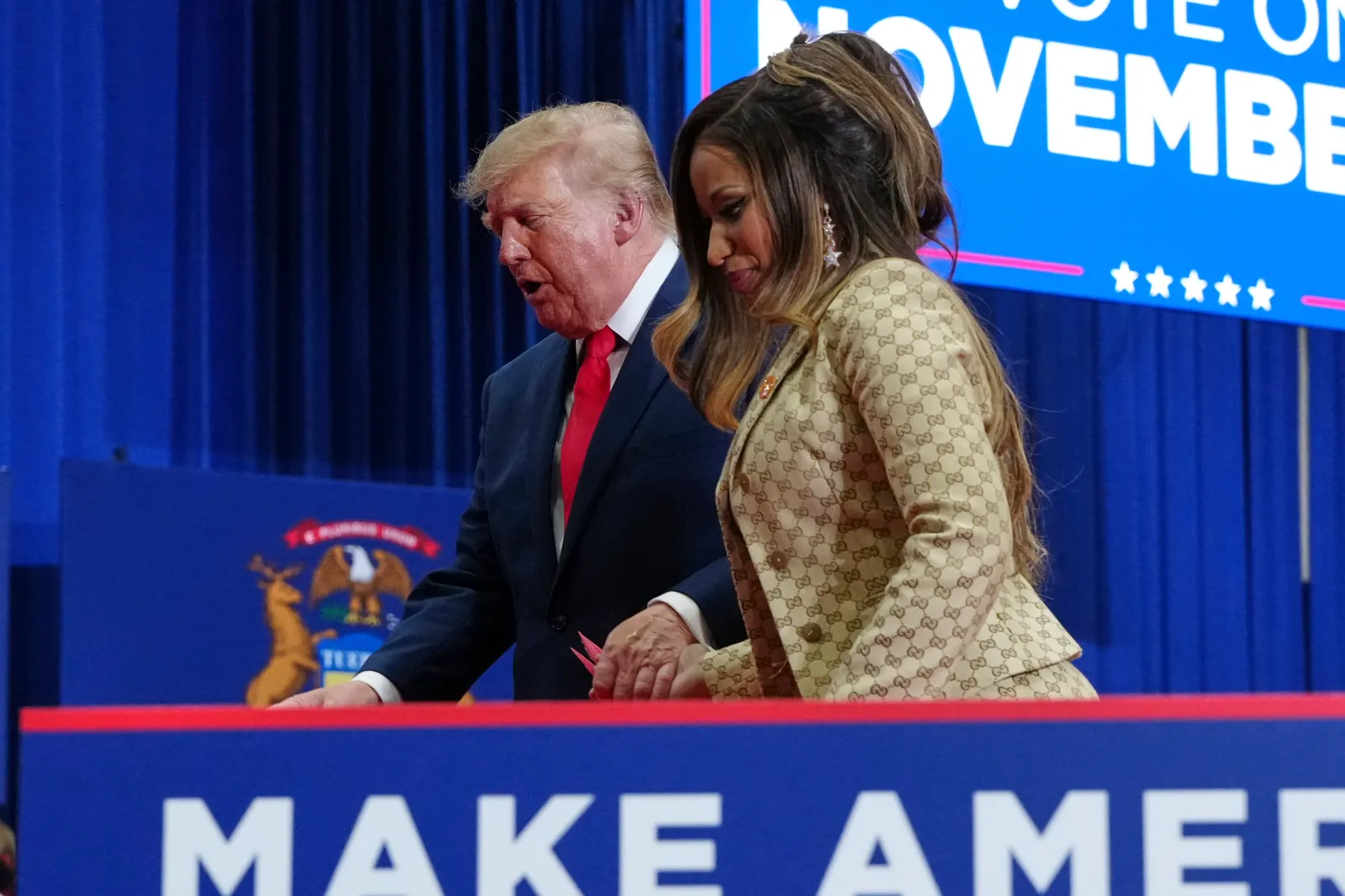 President Donald Trump, left, escorts Nicki Minaj off stage after Minaj spoke during a campaign rally at McMorran Place Sports and Entertainment Center, Sunday, October 25, 2026, in Port Huron, Michigan.
