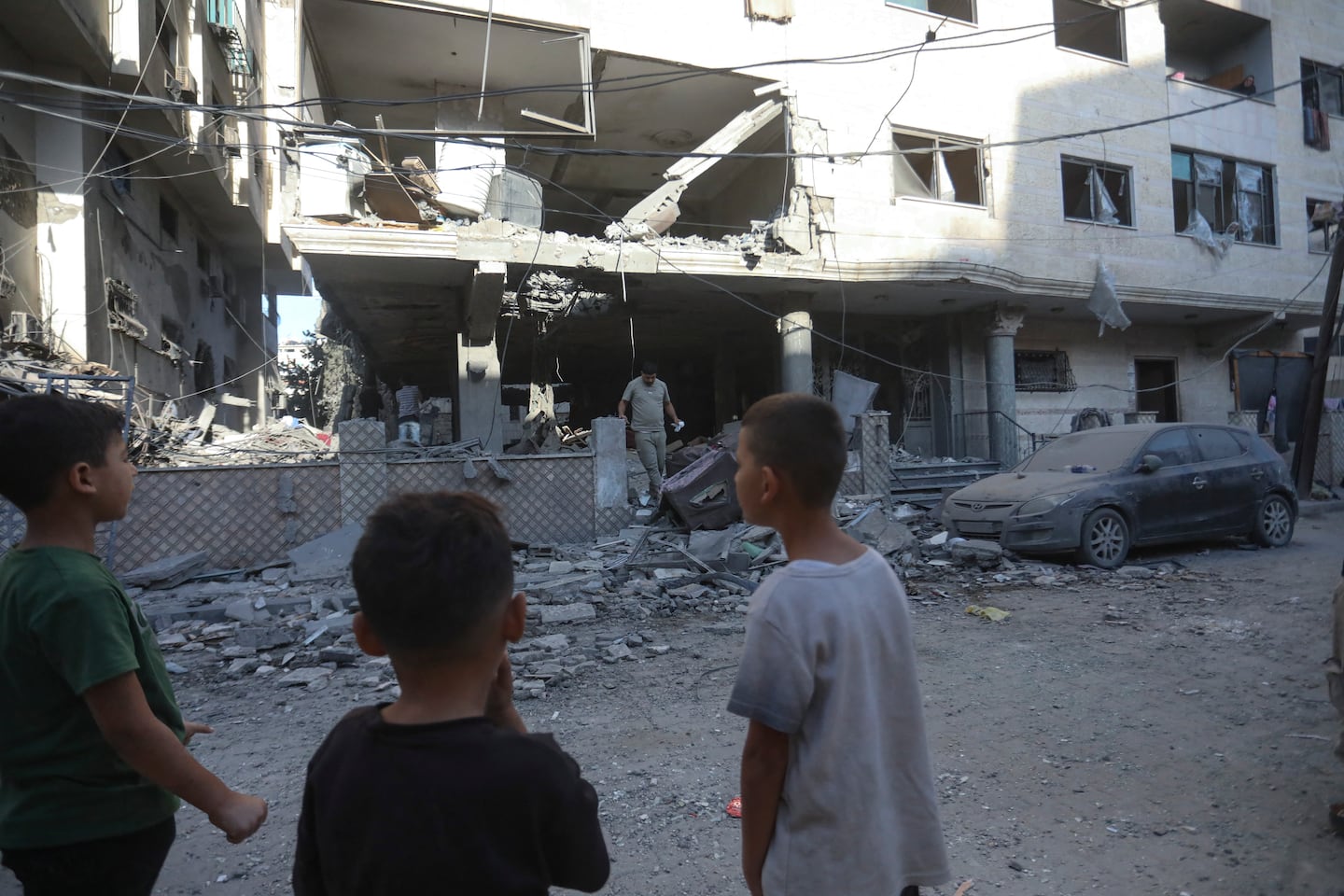 Children look at a damaged residential building in western Gaza City on Oct. 3, 2026. An overnight Israeli airstrike in western Gaza City killed Maisa Daoud and her daughter Mary, causing damage to nearby structures.