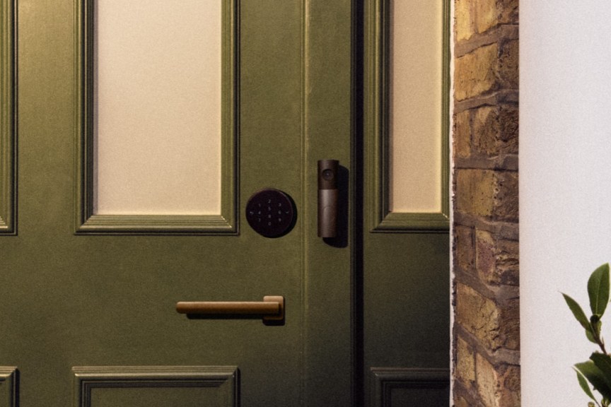 Apple smart lock and video doorbell on a wood door.