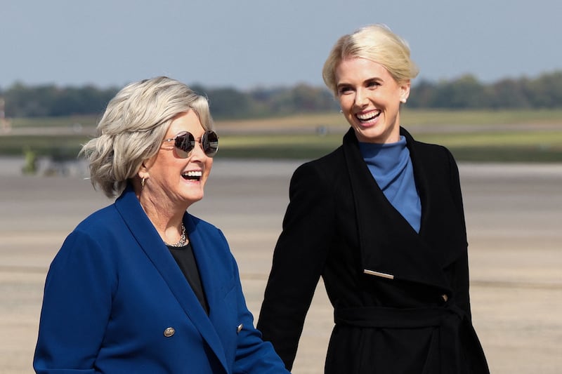 White House Chief of Staff Susie Wiles and US President Donald Trump's Executive Assistant Natalie Harp react as they board Air Force One en route to Georgia for a campaign rally, at Joint Base Andrews, Maryland, US, October 16, 2026.  REUTERS/Kevin Lamarque